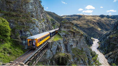 The Taieri Gorge Train offers a scenic journey through New Zealand’s rugged landscapes, featuring live commentary on the region’s history and natural beauty.