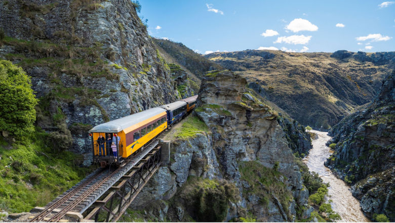 The Taieri Gorge Train offers a scenic journey through New Zealand’s rugged landscapes, featuring live commentary on the region’s history and natural beauty.